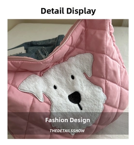 Detail of pink quilted tote bag featuring a cute plush dog patch and smooth metal zipper