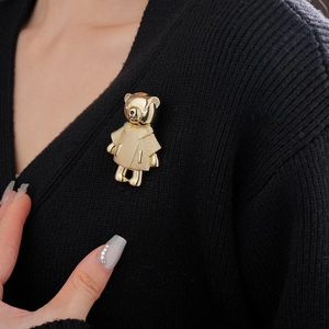 Nahaufnahme einer goldenen Bärenbrosche mit Diamanten an einer schwarzen Strickjacke