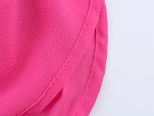 Dettaglio delle cuciture sottili e della trama del vestito in chiffon fucsia