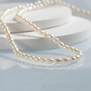 Macro shot of 5-6mm natural freshwater rice pearls on a white circular display stand