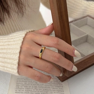 Close-up of retro gold plated silver ring with black oval onyx stone on hand