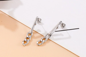 Detail of silver titanium steel drop earrings with sleek metal bars and geometric chains
