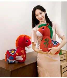 Chinese style red horse plush toy with traditional embroidery held by a model