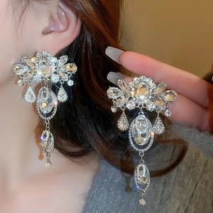 Gros plan de boucles d'oreilles à pampilles argentées avec cristaux sur un mannequin