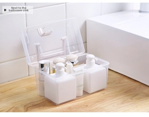 Close-up of a clear plastic storage box with a handle used on a bathroom countertop