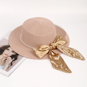 Pink straw sun hat with white pearl chain and elegant gold satin bow for summer beach