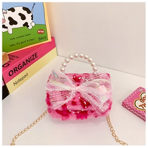 Close-up of plush children handbag with pearl handle and lace bow detail