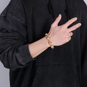 Fashion skull charm bracelet in gold-tone stainless steel worn by a male model