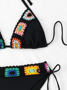 Close-up of colorful crochet flower trim and knitted texture on a black bikini top