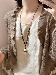 Détail d'un collier de perles en bois avec pendentif en forme de lotus blanc sculpté