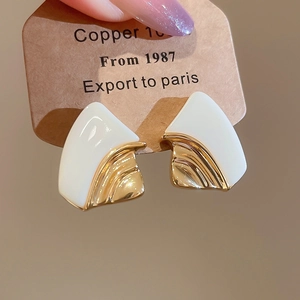 Macro view of geometric fan earrings with 18k gold plating and white resin finish