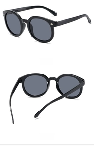 Vue détaillée de lunettes de soleil rondes pour enfants avec rivets et verres gris foncé