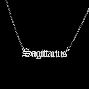 Macro detail of silver Sagittarius gothic script pendant on stainless steel chain