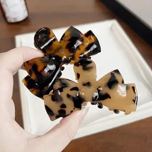 Large acetate bow claw clips in tortoise shell patterns for elegant hair styling