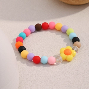 Detail of colorful matte beads bracelet featuring a yellow flower and faceted crystals