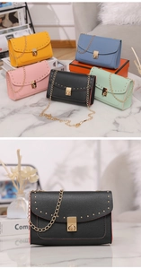 Macro detail of chic rivet trim and gold twist-lock on a square chain bag for women