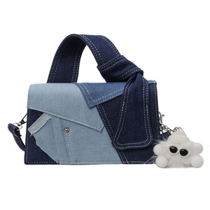 Sac à main en patchwork de denim bleu avec pendentif monstre blanc et poignée nouée