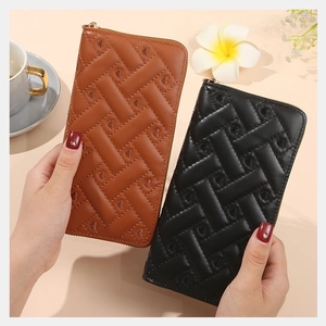 Close-up of brown and black heart embossed quilted leather long wallets with gold zippers