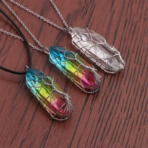 Three Tree of Life crystal pendants with wire-wrapped tree design on dark wood background