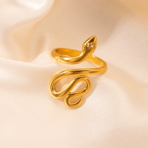 Macro shot of gold snake ring with 18K plating on soft silk fabric luxury background