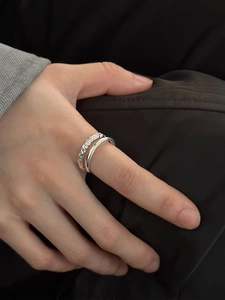 Detail of silver double-layered stacked rings featuring minimalist smooth and twisted bands