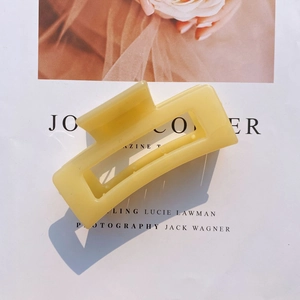 Detail of a pale yellow matte acrylic rectangular claw clip on a stylish magazine