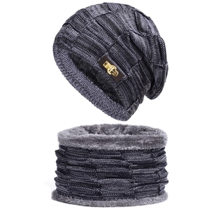 Dettaglio di cappello e scaldacollo in maglia con fodera in pile e logo in metallo