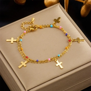 Double-layer gold chain bracelet with colorful beads and cross pendants on jewelry box