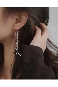 Macro shot of long sterling silver tassel drop earrings showing elegant flowing lines