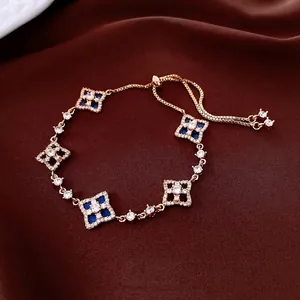 Adjustable gold bracelet featuring shell flower charms with blue stones and zircons