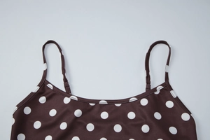 Détail des bretelles réglables et de l'imprimé à pois sur la robe moulante marron