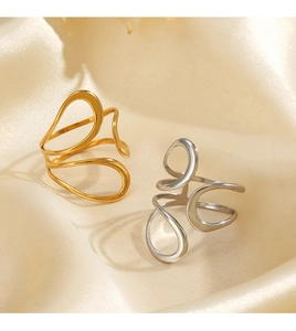 Detail of fluid wavy hollow rings in polished gold and silver on silk fabric