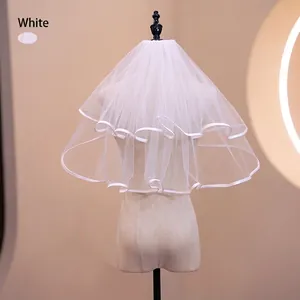Detail of white two-layer short bridal veil with elegant satin ribbon edge on a mannequin