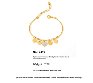 Macro detail of 18k gold plated heart charm bracelet with sparkling zircon inlay