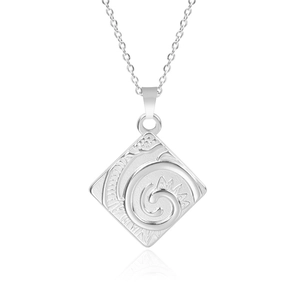 Close-up of square stainless steel pendant with swirl gear texture on fine chain