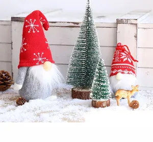 Detail of Christmas gnome plush set with miniature tree and deer on snowy background