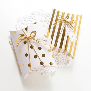 White gold foil pillow gift boxes with polka dots, stripes, and golden ribbons