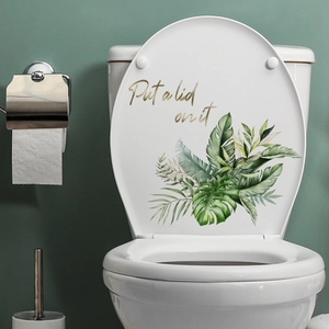 Detail of tropical leaf wall sticker with golden Put a lid on it text for bathroom decor