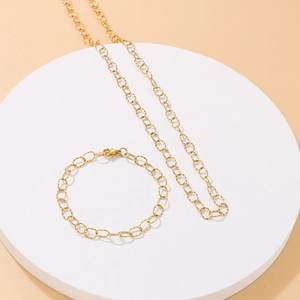 Elegant gold hollow oval link necklace and bracelet jewelry set on white display