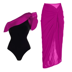 Detail of ruffled one-shoulder bodysuit paired with a ruched pink skirt ensemble