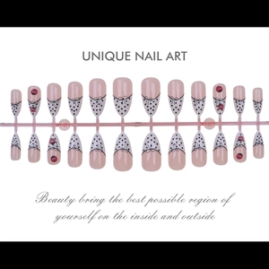 Detailed set of 24 pink almond press-on nails with black bows and polka dot patterns
