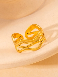 Macro detail of wave-shaped triple-layer golden titanium steel ring with hollow design