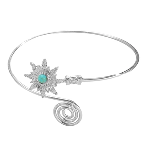 Detailed view of silver sunburst arm cuff featuring a centered turquoise stone accent