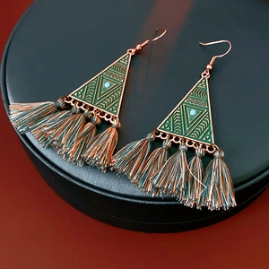 Detailed shot of ethnic triangle earrings with turquoise beads and green tassels