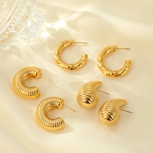 Three pairs of vintage gold C-shaped earrings and studs with textured metallic finish