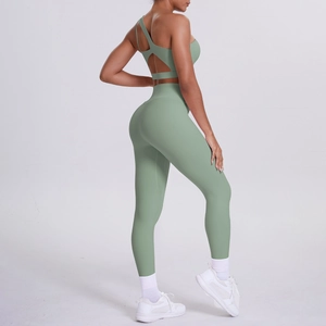 Detail of sage green yoga set showing asymmetric open back bra and high-waist leggings
