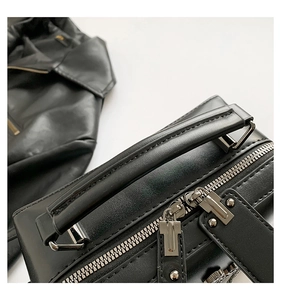 Detailed close-up of premium black leather bag featuring silver zippers and sturdy handle