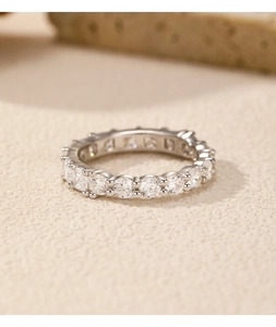 Macro shot of silver ring with pavé-set round clear crystals on a textured surface