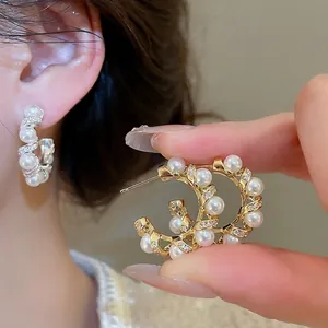 Elegant gold plated C-shaped earrings with pearls and pavé cubic zirconia accents