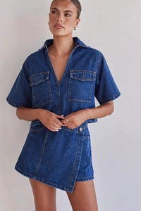 Detail of dark blue denim cargo set featuring irregular short sleeve top and wrap skirt